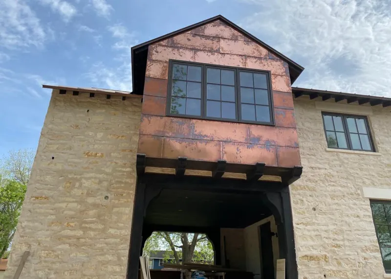 Copper metal panel facade on a stone building for Skylight Installation in Highland
