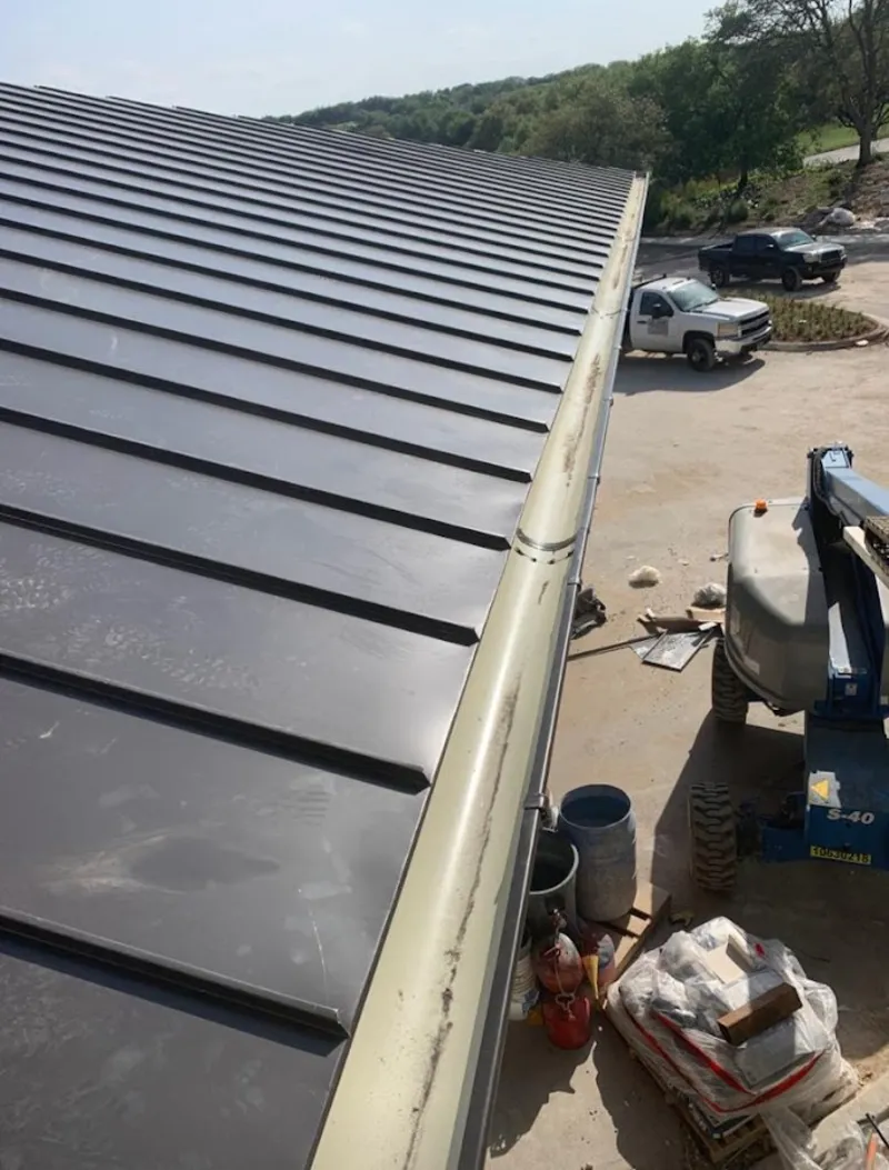 Standing seam panel and gutter detail on a metal roofing jobsite in Highland